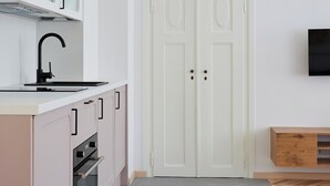 Una cocina moderna con armarios blancos, un grifo negro y un horno empotrado.