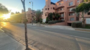 A residential building with multiple balconies, a clear road, and a speed limit sign of 30. - Casa Serenidad Mar Menor Golf Resort (Torre Pacheco)