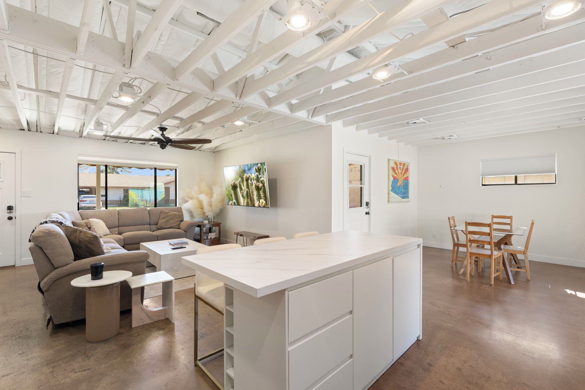 A modern interior with a sofa, coffee table, dining table, and chairs.