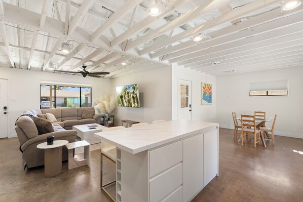 A modern interior with a sofa, coffee table, dining table, and chairs.