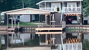 A waterfront house with a covered deck and a balcony.