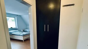 Une chambre à coucher avec un lit, une fenêtre et une porte sombre.
