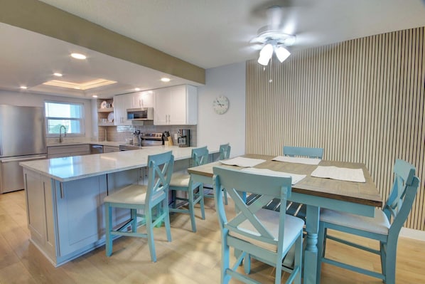 Une cuisine moderne dotée d’un îlot central, d’une table à manger et de chaises.