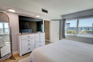 Une chambre avec un lit, une commode et une vue sur la plage.
