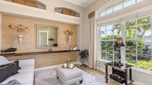 A spacious living room with a large window, a fireplace, and a modern fireplace screen.