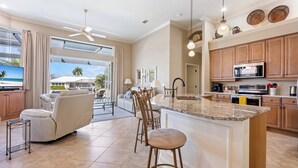 A spacious living area with a large TV, comfortable seating, and a view of the outdoors.