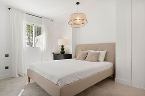 A bedroom with a bed, a nightstand, a lamp, and a window with curtains. - 5 BR Luxury apt w Pool,  garage and amazing views (Marbella)