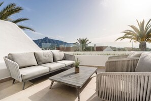 A rooftop terrace with a sofa, chairs, and a table. - 5 BR Luxury apt w Pool,  garage and amazing views (Marbella)