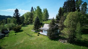 A house with a large lawn, surrounded by trees and a mountain in the background. - Vacation home Marta by Interhome (Smržovka)