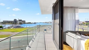 A balcony with a view of a marina and a cityscape.