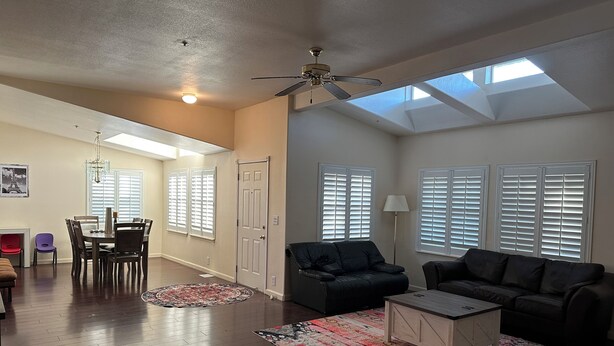 A spacious living room with a high ceiling, skylight, and a dining area with a chandelier. - 3BR Farmhouse Getaway, Group-Friendly, WiFi, AC, Trails (Warner Springs)