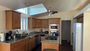 A kitchen with wooden cabinets, a microwave, stove, and a refrigerator. - 3BR Farmhouse Getaway, Group-Friendly, WiFi, AC, Trails (Warner Springs)