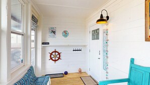 A cozy room with a patterned bench, a ship's wheel decoration, and a sign reading "Parch Potatoes." - Pet Friendly, Old Town Location, Golf Cart Access, Close to the Beach (Port Aransas)