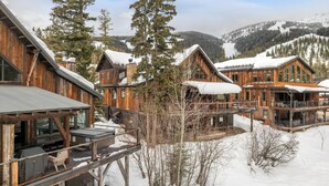 Un chalet en bois comprenant plusieurs cabines, chacune dotée d’un balcon et offrant une vue sur le paysage enneigé environnant.