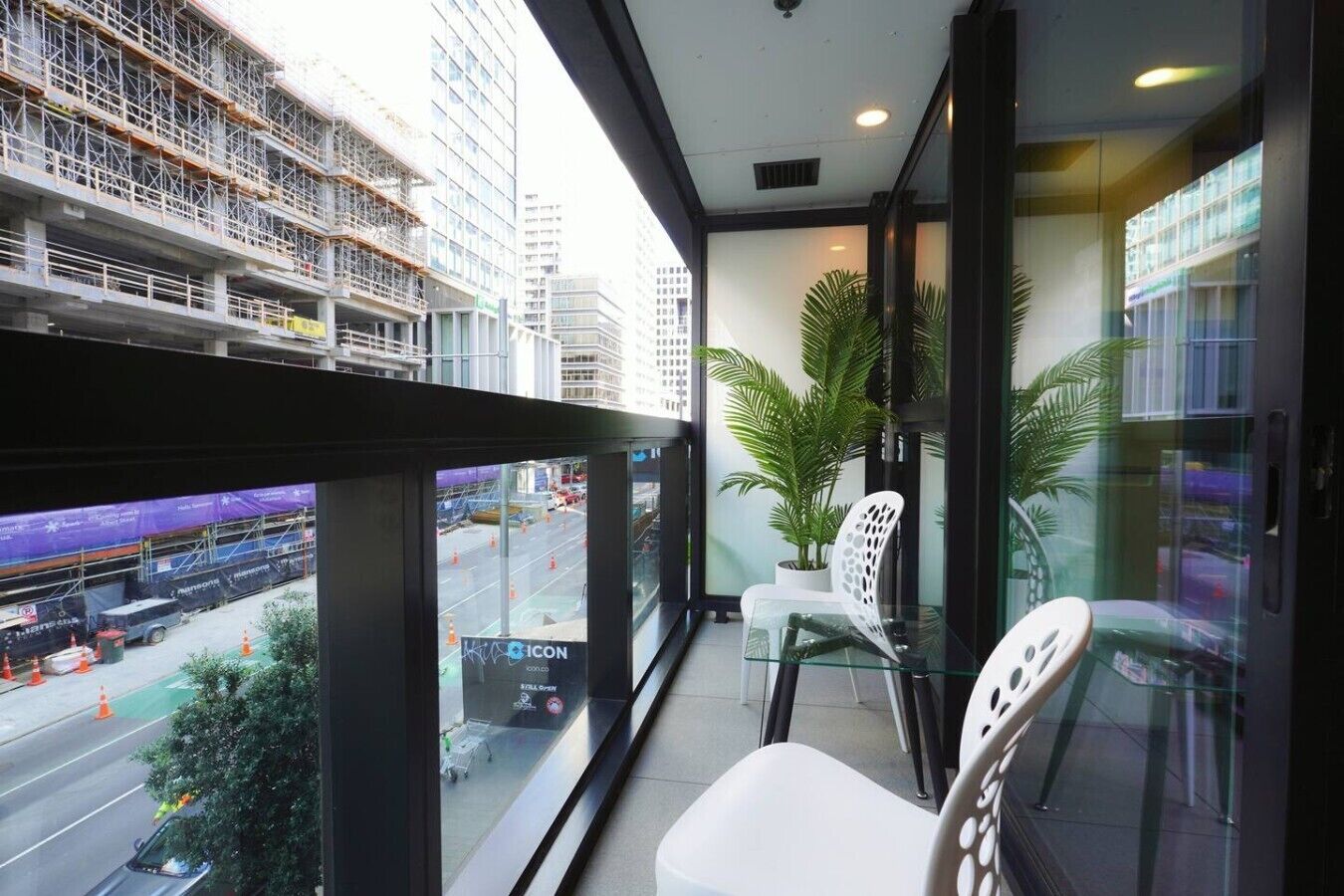 Un balcon donnant sur un chantier de construction et sur le paysage urbain.