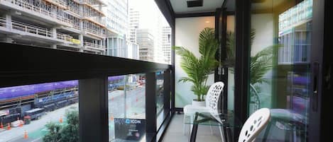 Un balcon donnant sur un chantier de construction et sur le paysage urbain.