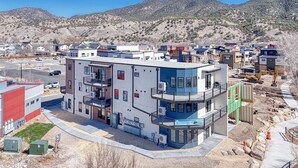 A modern hotel with a multi-story structure, balconies, and a view of the surrounding area. - The Mayfly Hotel, Unit 1E (Salida)