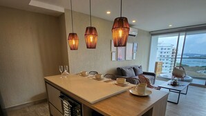 A modern kitchen with a central island, built-in appliances, and pendant lighting. - Relax and comfort| Apartment with private jacuzzi (La Boquilla)