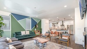 A modern living room with a sofa, coffee table, and dining area.