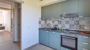 A modern kitchen with teal cabinets, a patterned backsplash, and a built-in oven. - 5 bedroom nice home in Bovalino (Bovalino)