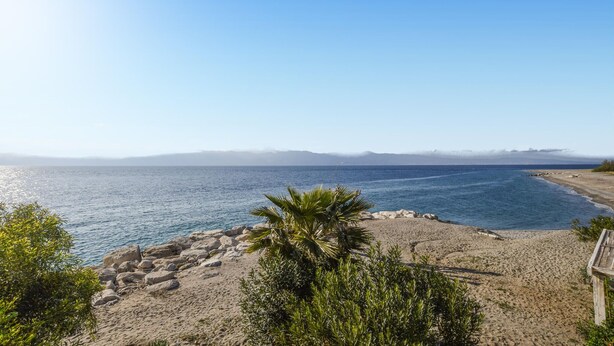 A beach with clear blue water, rocky shoreline, and distant mountains. - 5 bedroom nice home in Bovalino (Bovalino)