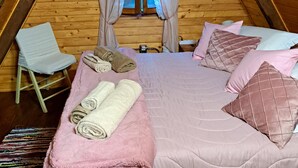 Une chambre confortable avec un lit, des oreillers et des serviettes enroulées.