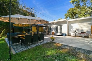 En terrasse med udendørs møbler, et overdækket siddeområde og en grill.