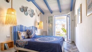 A bedroom with a bed, wooden floor, and a view to the outside. - Le Rêve by Interhome (Valledoria)