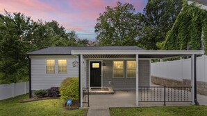 A single-story house with a covered porch, a front door, and a small front yard.
