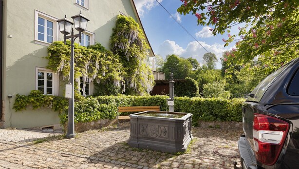 A cobblestone street, a bench, a water fountain, and a building with ivy. - Holiday Apartment 'Fleur' with Wi-Fi (Tengen)
