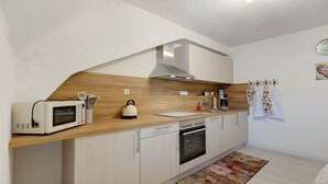 A modern kitchen with a microwave, kettle, coffee maker, and oven. - Holiday Apartment 'Fleur' with Wi-Fi (Tengen)