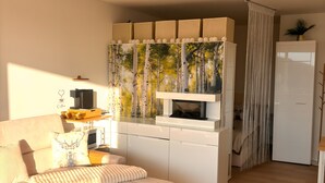 A modern living room with a sofa, coffee table, and a kitchen area with a microwave.