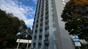 A tall, modern building with a sign indicating 'Euro Hoch Haus' and a parking sign nearby.