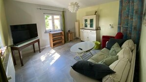 A living room with a TV, sofa, and dining table.