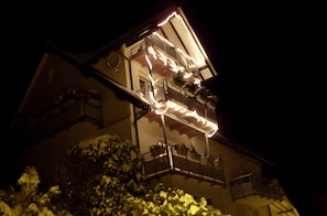 Un edificio de varios pisos con balcones, una escalera y un techo cubierto de nieve.