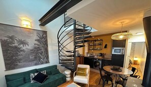 A modern interior with a spiral staircase, a dining area, and a kitchen.