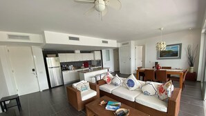 A modern living room with a sofa set, a coffee table, and a dining area with a table and chairs.