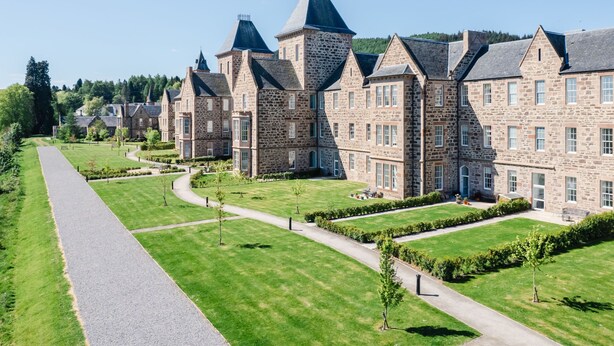 A large stone building with multiple towers and a well-maintained lawn. - Great Glen View by Interhome (Inverness)
