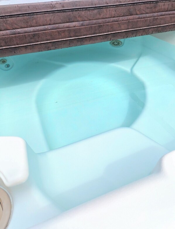 A toilet with a light blue interior and a wooden frame above it.