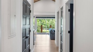 A hallway leading to a patio with a view of greenery.