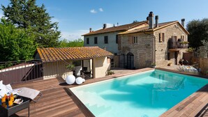 A stone house with a swimming pool, wooden deck, and outdoor seating area. - Annalisa by Interhome (Montaione)