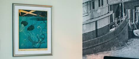 Quarto de hotel com uma cama, um quadro na parede e uma fotografia grande em preto e branco.