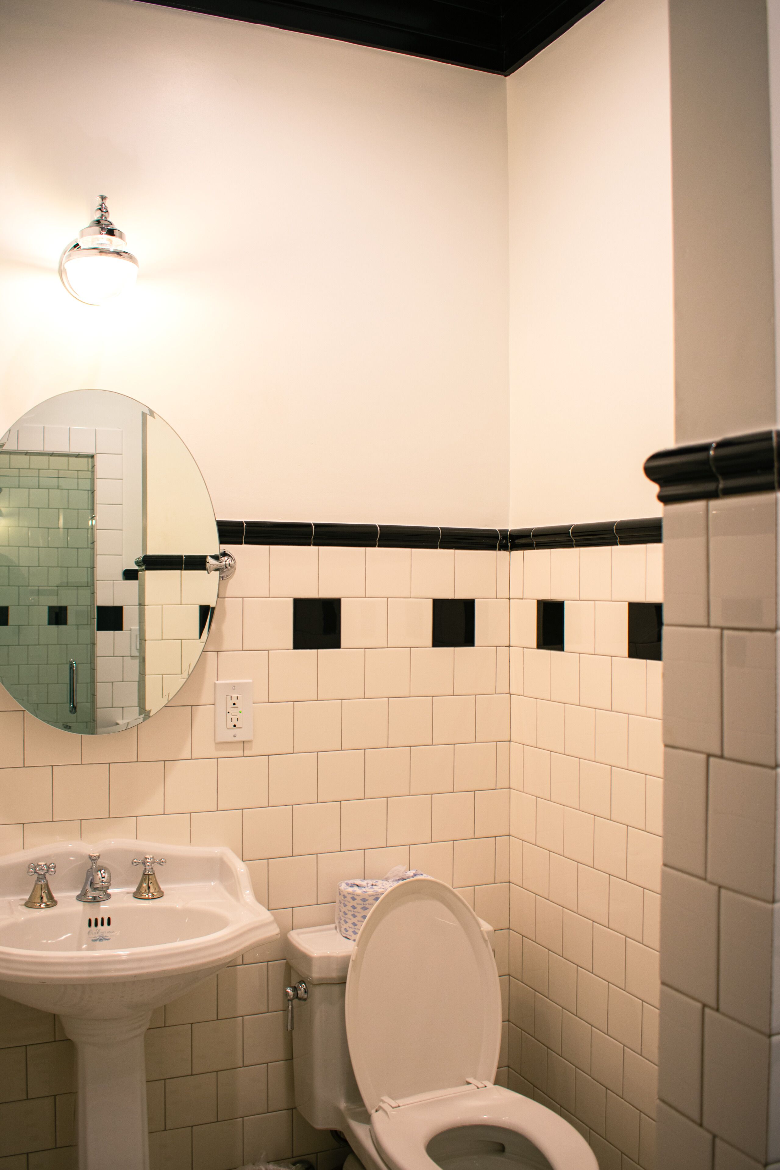 A bathroom with a sink, toilet, and mirror.