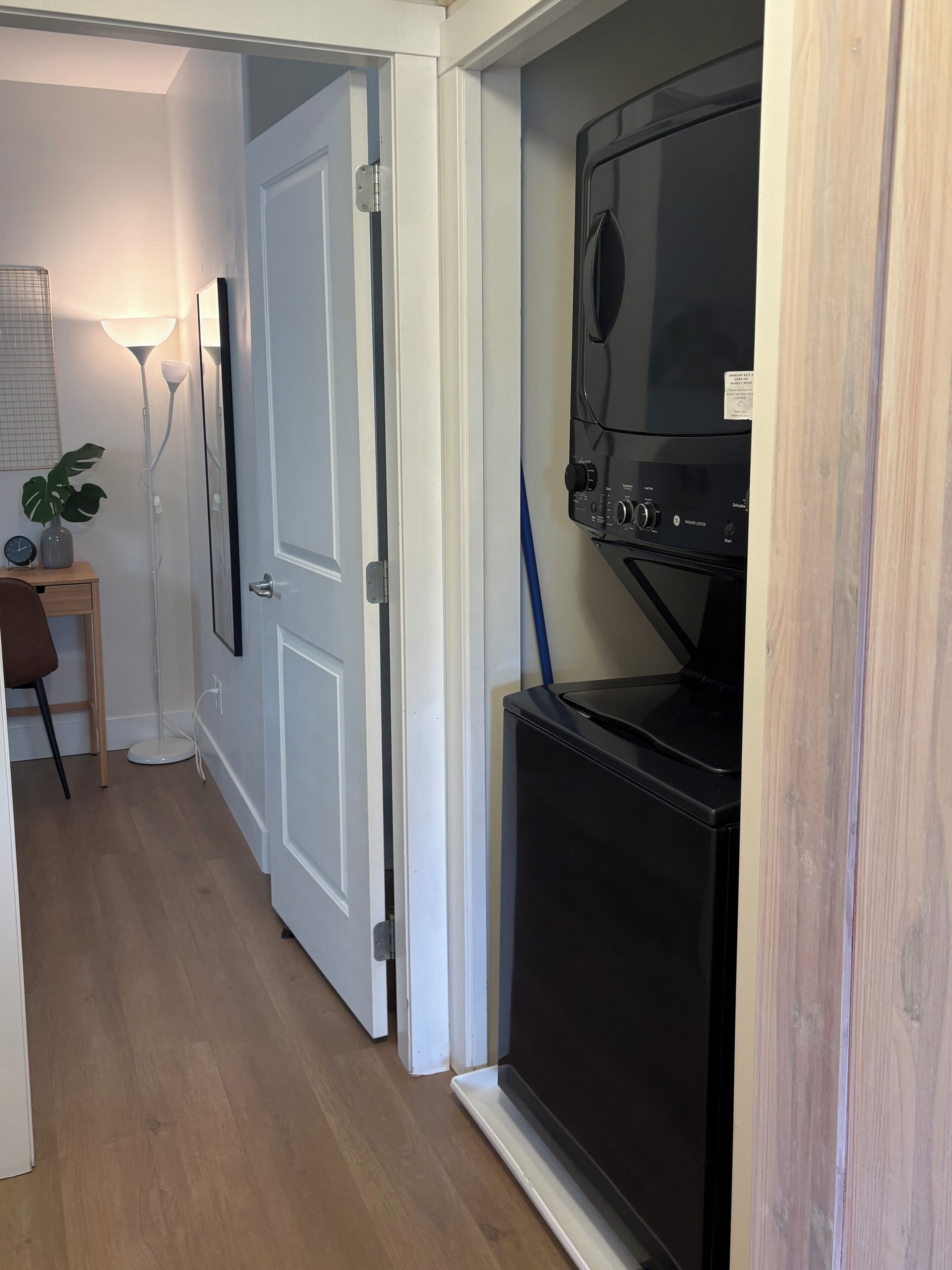 Una cocina compacta con microondas integrado, una pequeña encimera y una puerta que da a otra habitación.