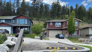 A residential area with houses, a driveway, and a stone staircase leading to a garage.