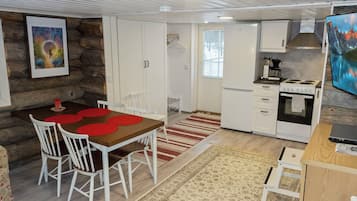 A compact kitchen with white cabinets, a stove, and a sink.