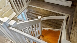 A wooden staircase with white railings leading to a lower level.