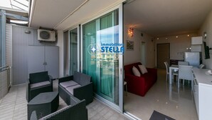 Un appartement moderne comprenant un coin repas, une cuisine et une porte vitrée donnant sur un balcon.