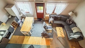 Ein kompakter Wohnbereich mit Küchenzeile, Essbereich und einer Sitzecke mit Sofa und Stühlen.