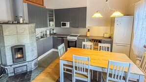 Eine moderne Küche mit einer zentralen Kochinsel, integrierten Geräten und einem Kamin aus Stein.